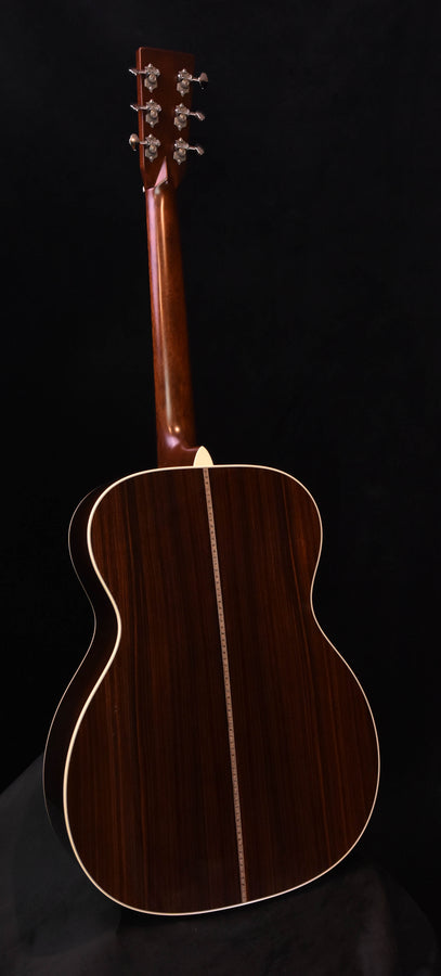 Acoustic-electric guitar with dark wood body and headstock tuning pegs