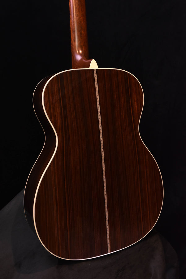 Dark wood acoustic-electric guitar body with cream binding and center seam