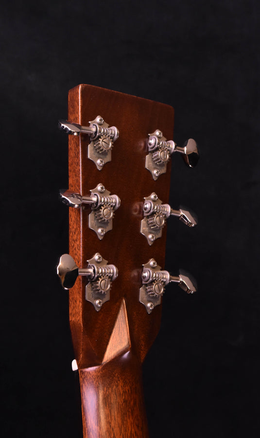 Acoustic-electric guitar headstock with chrome tuning machines on dark wood