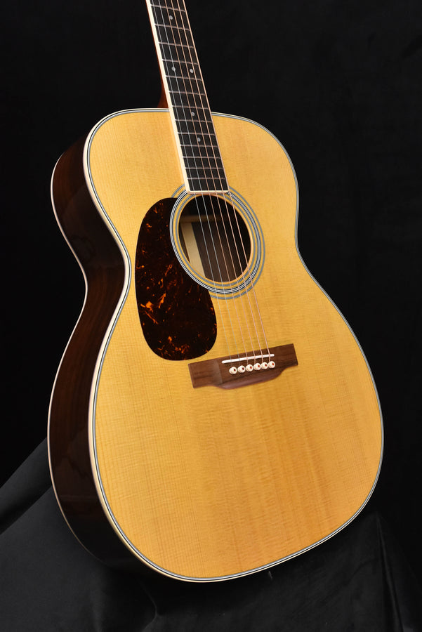 Left-handed acoustic guitar with sound hole rosette and natural finish