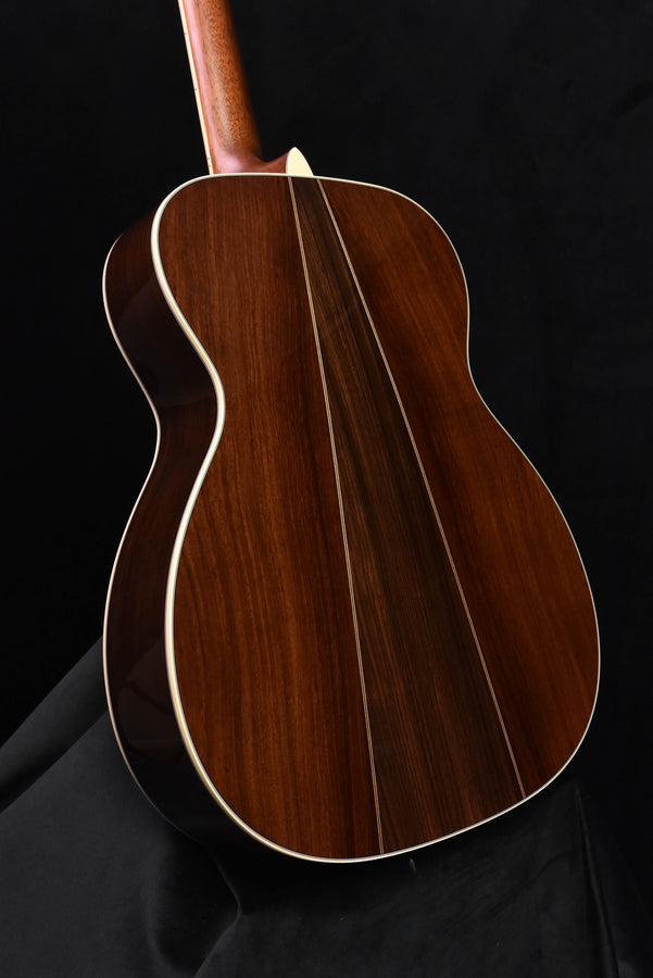 Acoustic guitar top view with dark wood body and white binding