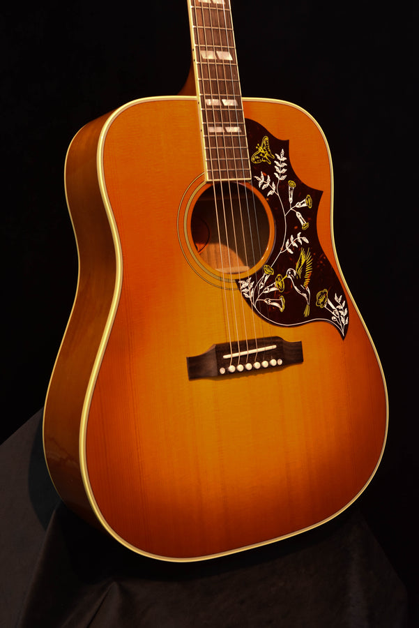 Cherry sunburst acoustic guitar, front close-up of soundhole, bridge, and pickguard