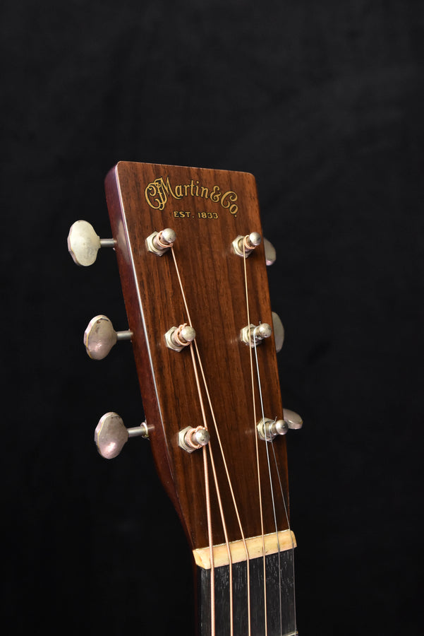 Headstock of amber burst acoustic guitar with Martin logo and tuning machines