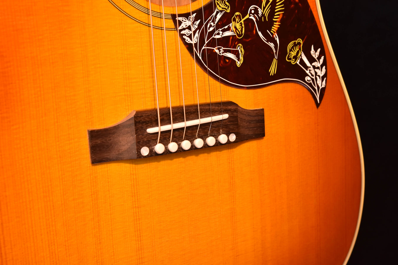 Cherry sunburst acoustic guitar, dark bridge with six white saddle pins