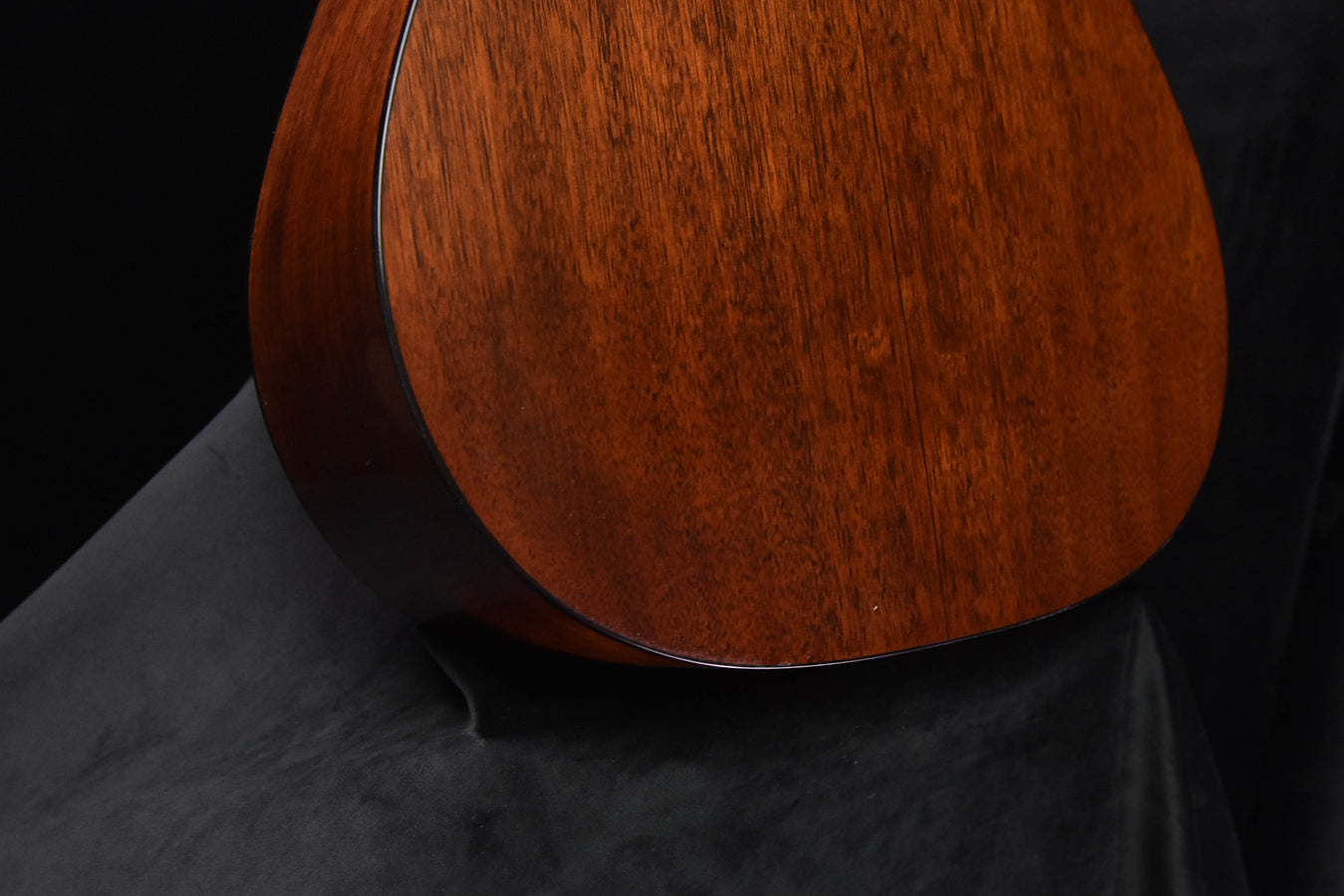 Amber burst acoustic guitar back close-up showing lower bout contours