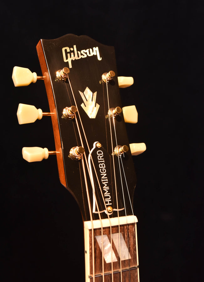 Gibson headstock and tuning machines, 'Hummingbird' logo on acoustic guitar