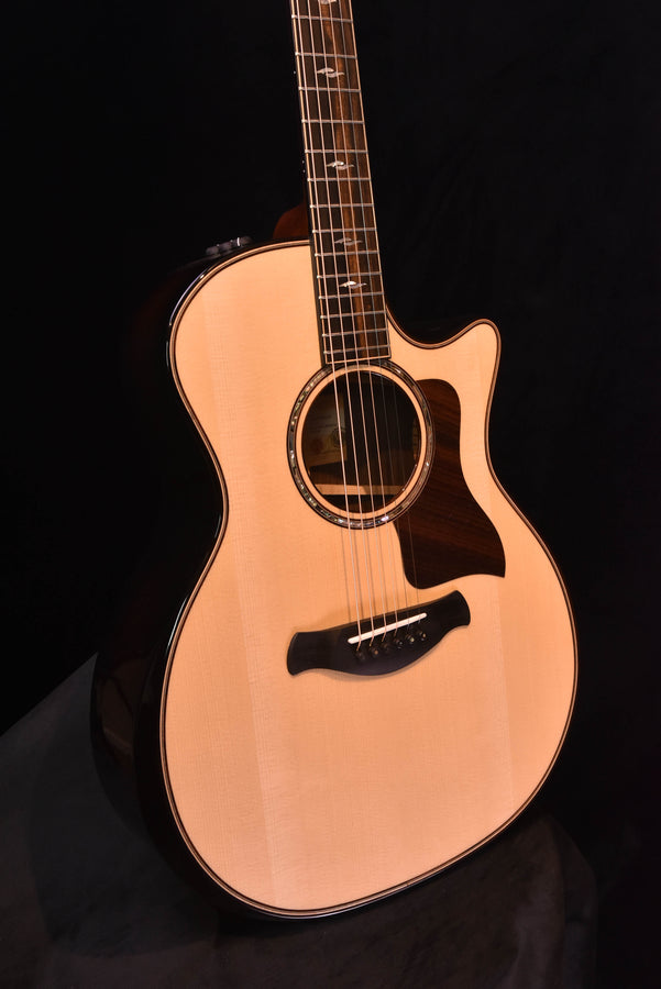 Acoustic-electric guitar with light wood top, round rosette, and dark pickguard