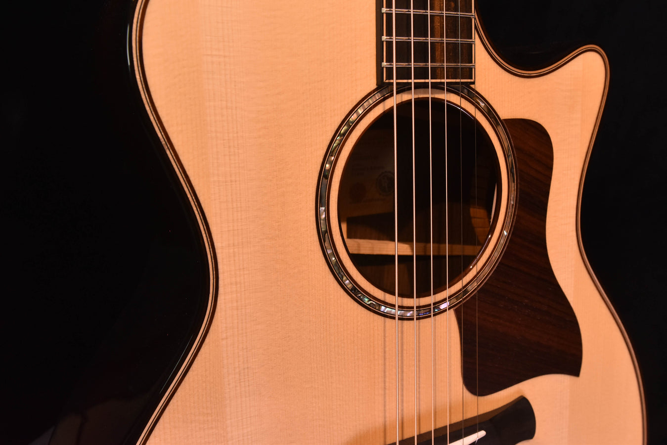 Close-up of guitar soundhole rosette on a light wood acoustic-electric body