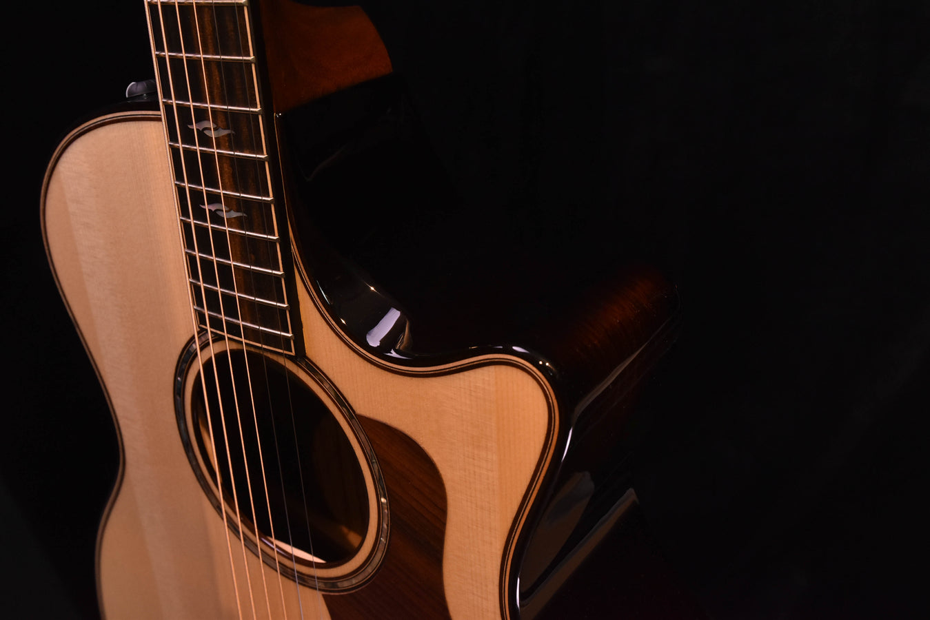 Angle view of acoustic-electric guitar neck, headstock, and light wood body