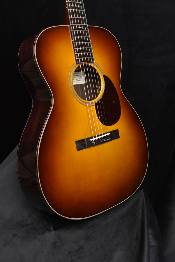 Sunburst OM acoustic guitar with rosette around soundhole and black pickguard