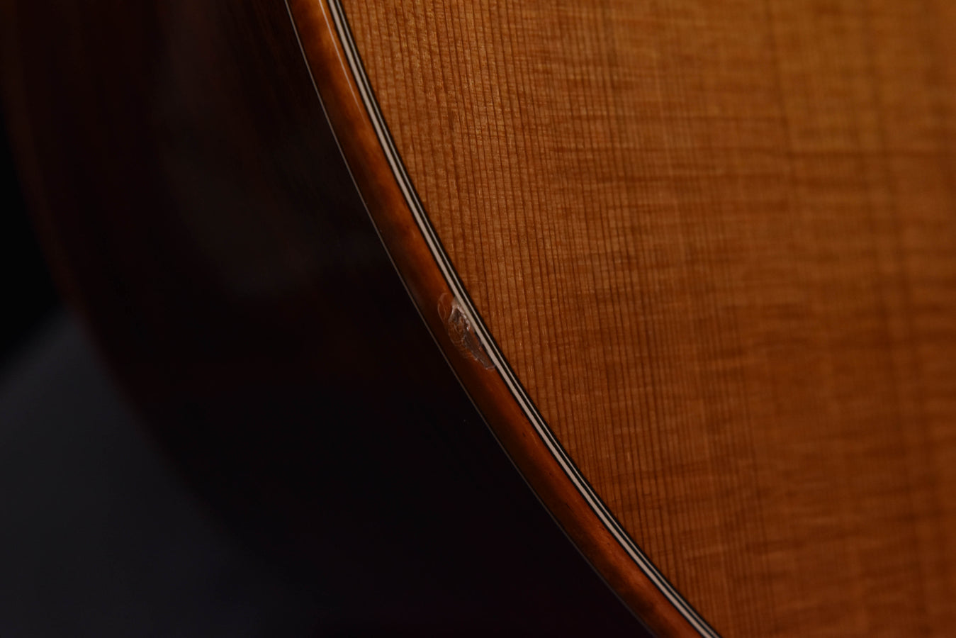 Used McPherson acoustic guitar, side profile showing wood finish and binding