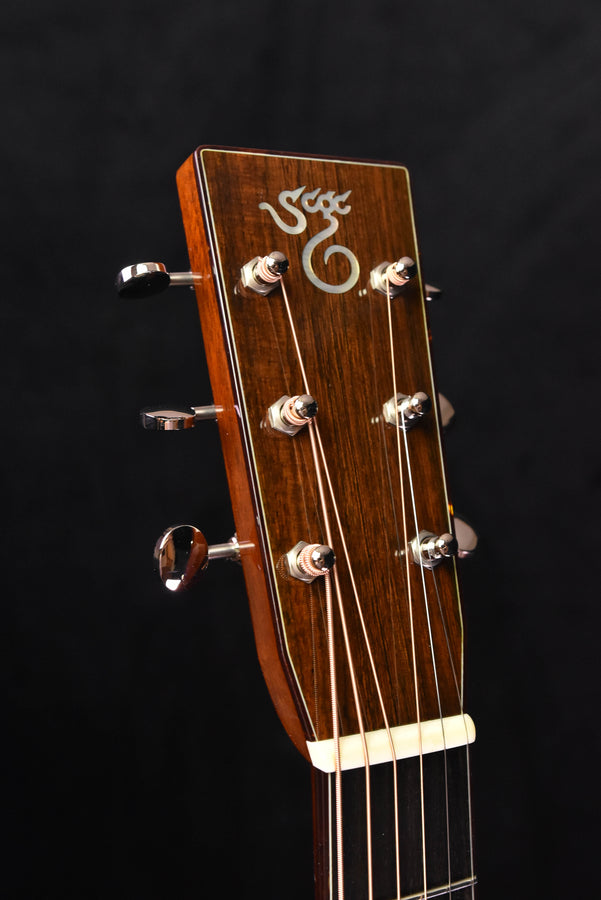 Acoustic guitar headstock with snowflake-style inlay and chrome tuning machines