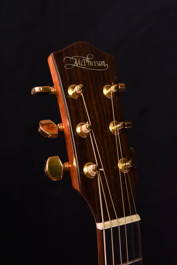 McPherson acoustic guitar headstock with gold tuners and logo