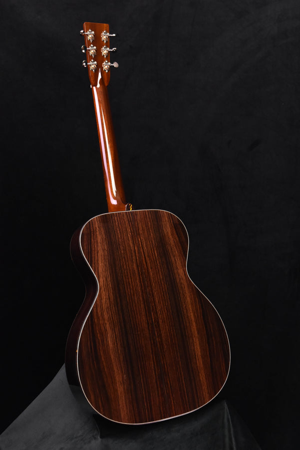 Sunburst OM acoustic guitar with glossy dark brown wood body and decorative rosette