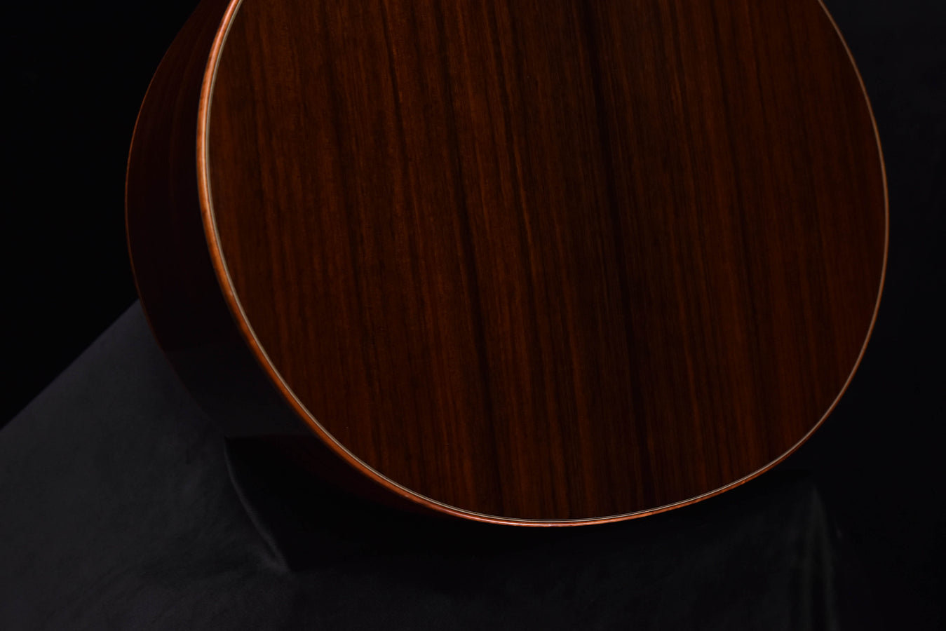 Acoustic guitar lower bout, dark wood with cream binding and visible grain