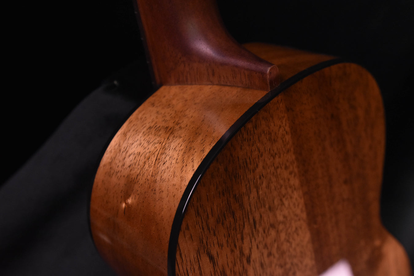 Koa ukulele body with black binding along the side