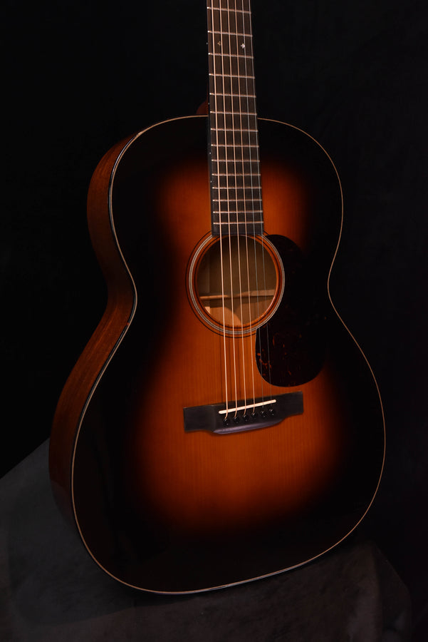 Acoustic guitar with dark sunburst top and soundhole rosette, close front view