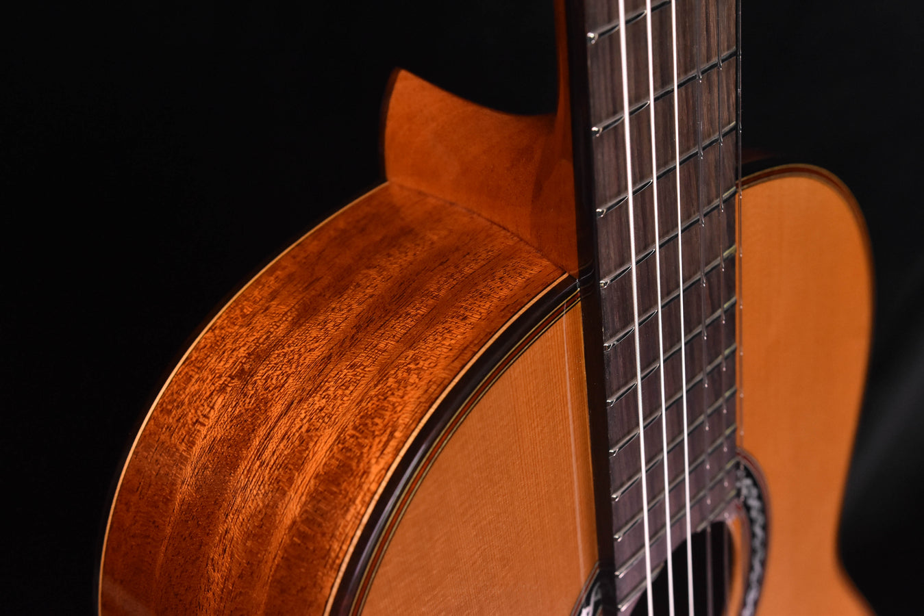 Cedar top classical guitar side view with soundboard edge and neck