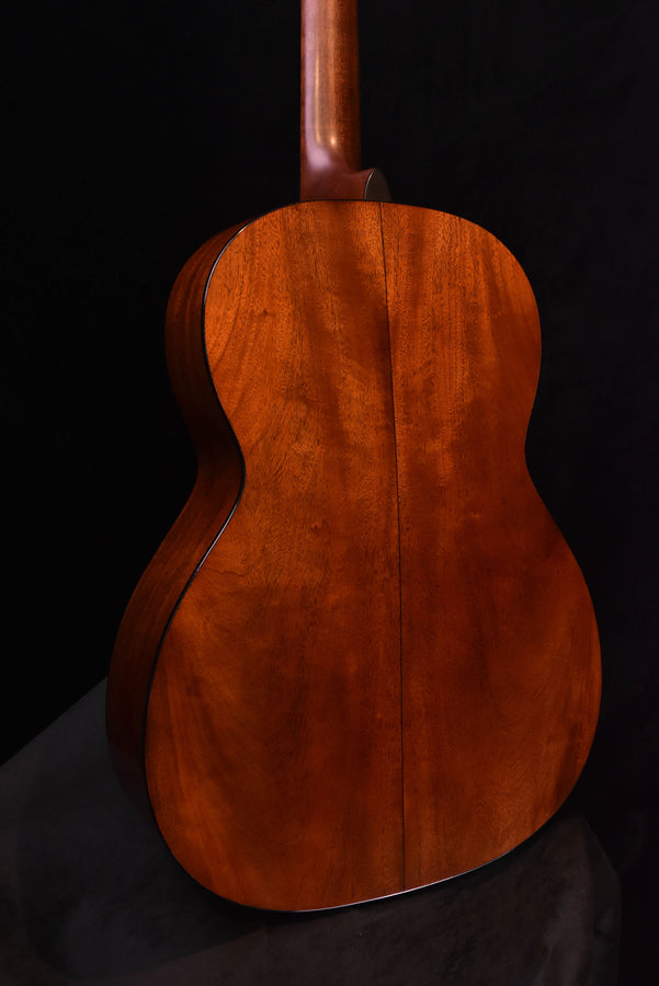Close back view of acoustic guitar body, visible center seam and wood grain