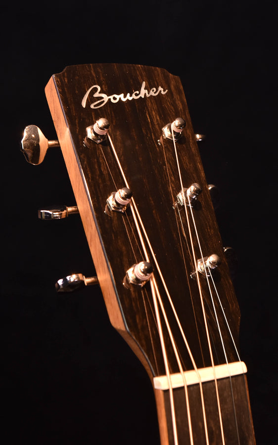Acoustic guitar headstock close-up with Boucher logo and tuning machines