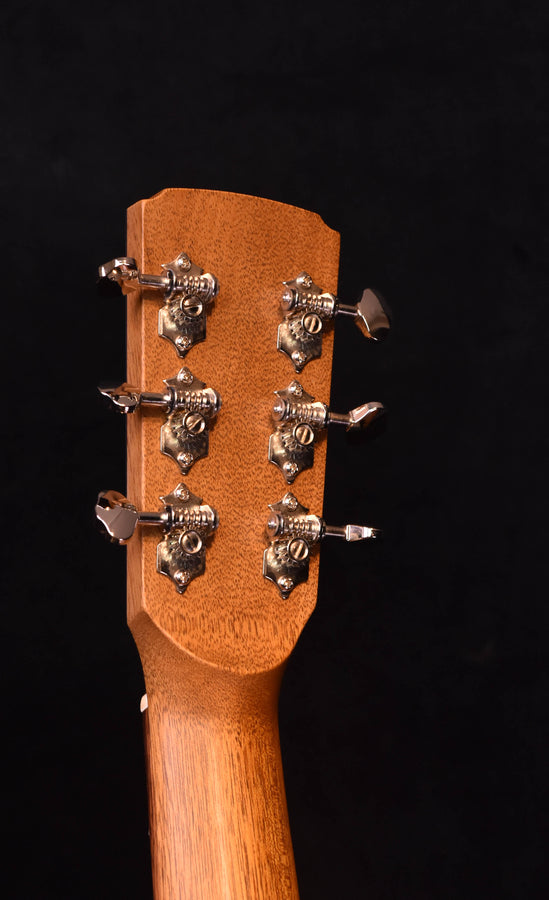 Acoustic guitar headstock with chrome tuning pegs on flamed maple veneer