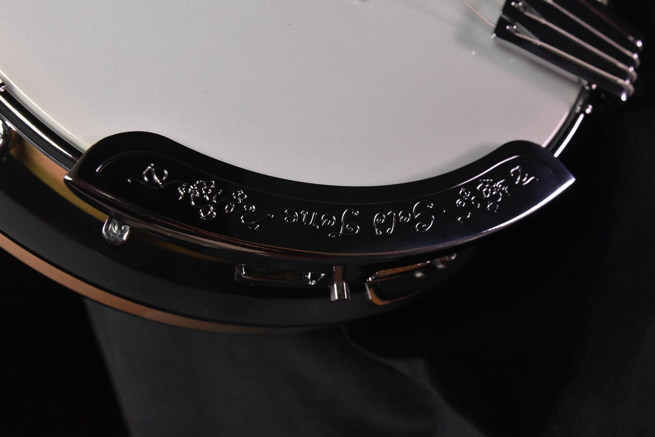Banjo rim detail with black resonator, decorative engraving, and chrome hardware
