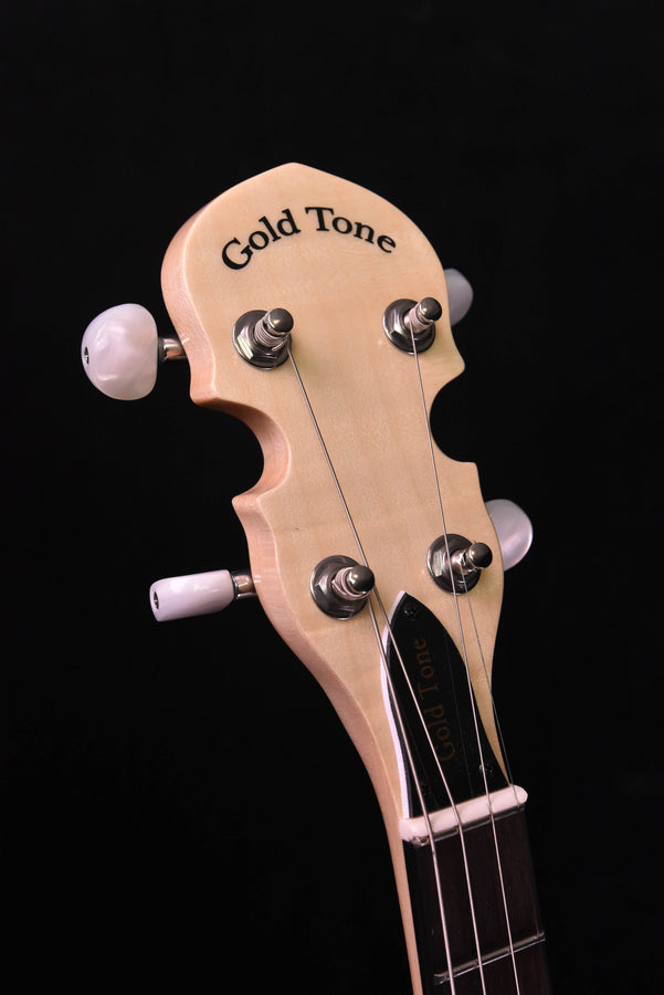 Banjo headstock with “Gold Tone” logo and four tuning pegs, light wood