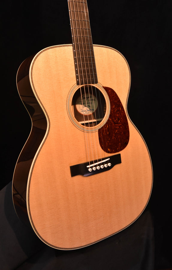Acoustic guitar front view with light spruce top, rosette around soundhole, dark wood pickguard
