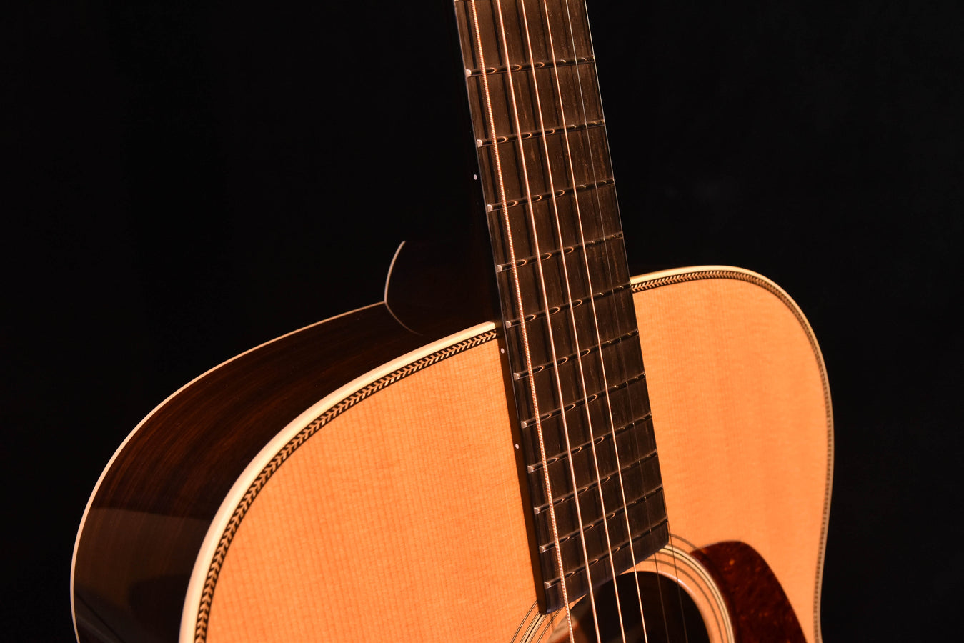 Acoustic guitar neck and upper bout close-up with dark side and light top