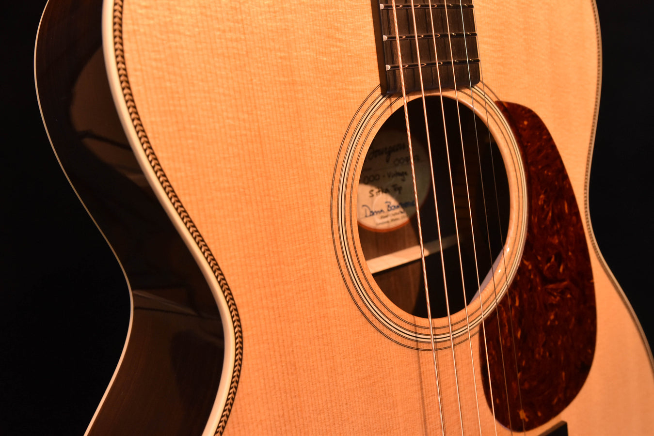 Close-up of acoustic guitar soundhole with rosette and dark bridge area below