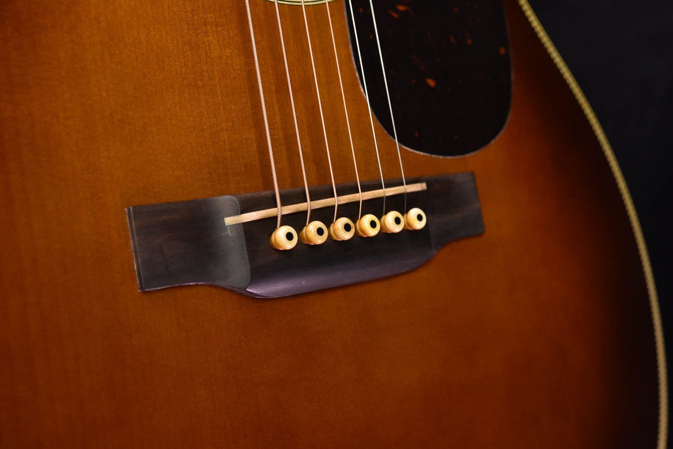 Steg und Saiten der Akustikgitarre Ambertone mit schwarzem Stegblech