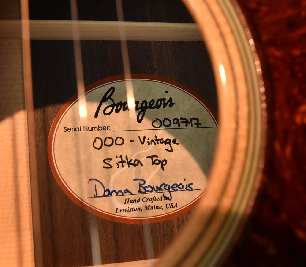 Acoustic guitar soundhole label with handwritten text and serial information
