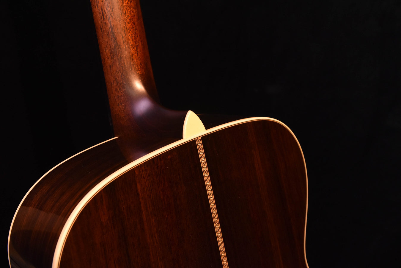 Acoustic guitar body edge and neck joint with cream binding trim on dark finish