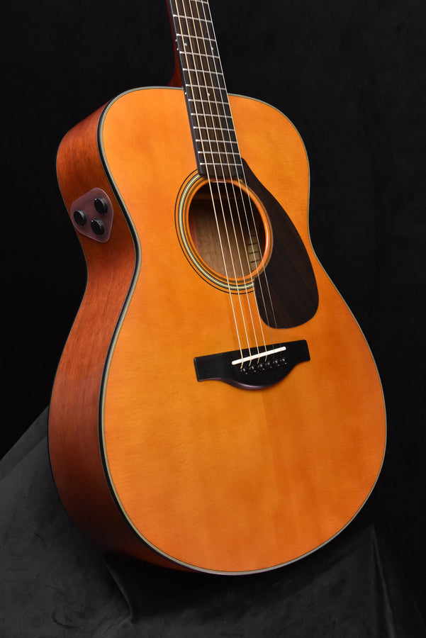 Acoustic-electric guitar body with sound hole, tortoiseshell-style pickguard, dark trim