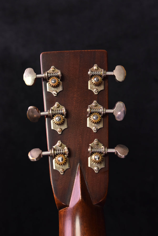 Headstock front with six tuning pegs and silver buttons; warm Ambertone finish