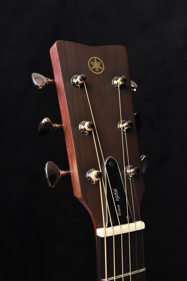 Acoustic-electric guitar headstock with Yamaha logo, tuning pegs, and string tuners
