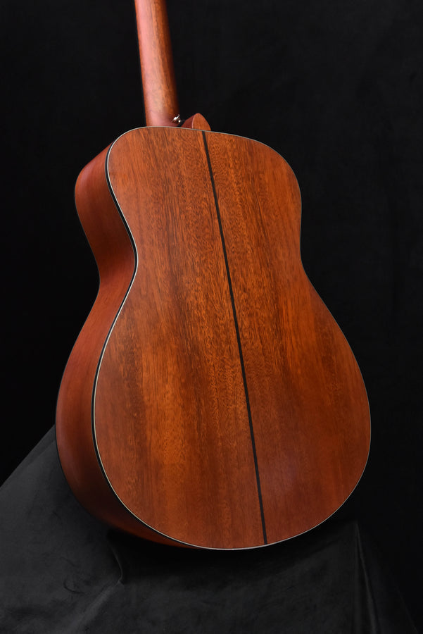 Back view of acoustic-electric guitar body with dark edge binding and wood grain