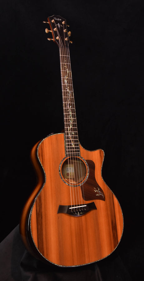 Acoustic electric guitar with carved soundhole rosette, natural brown wood finish, full body