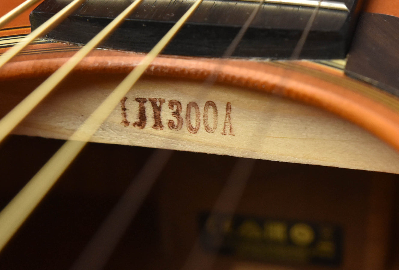Printed model code “YR300A” on guitar body near strings