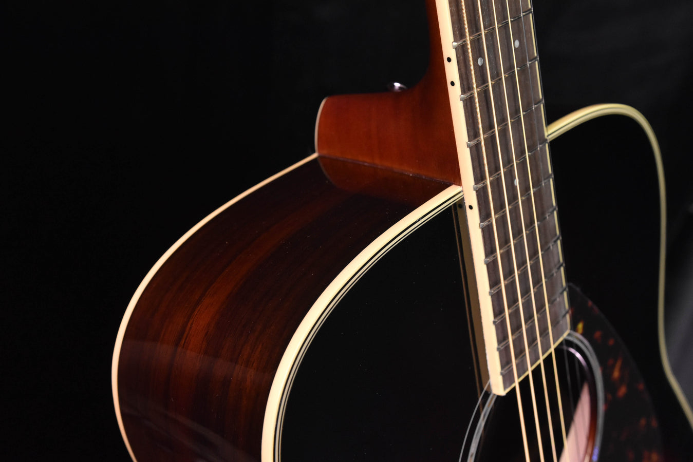 Sunburst acoustic guitar body side with white binding and neck joint