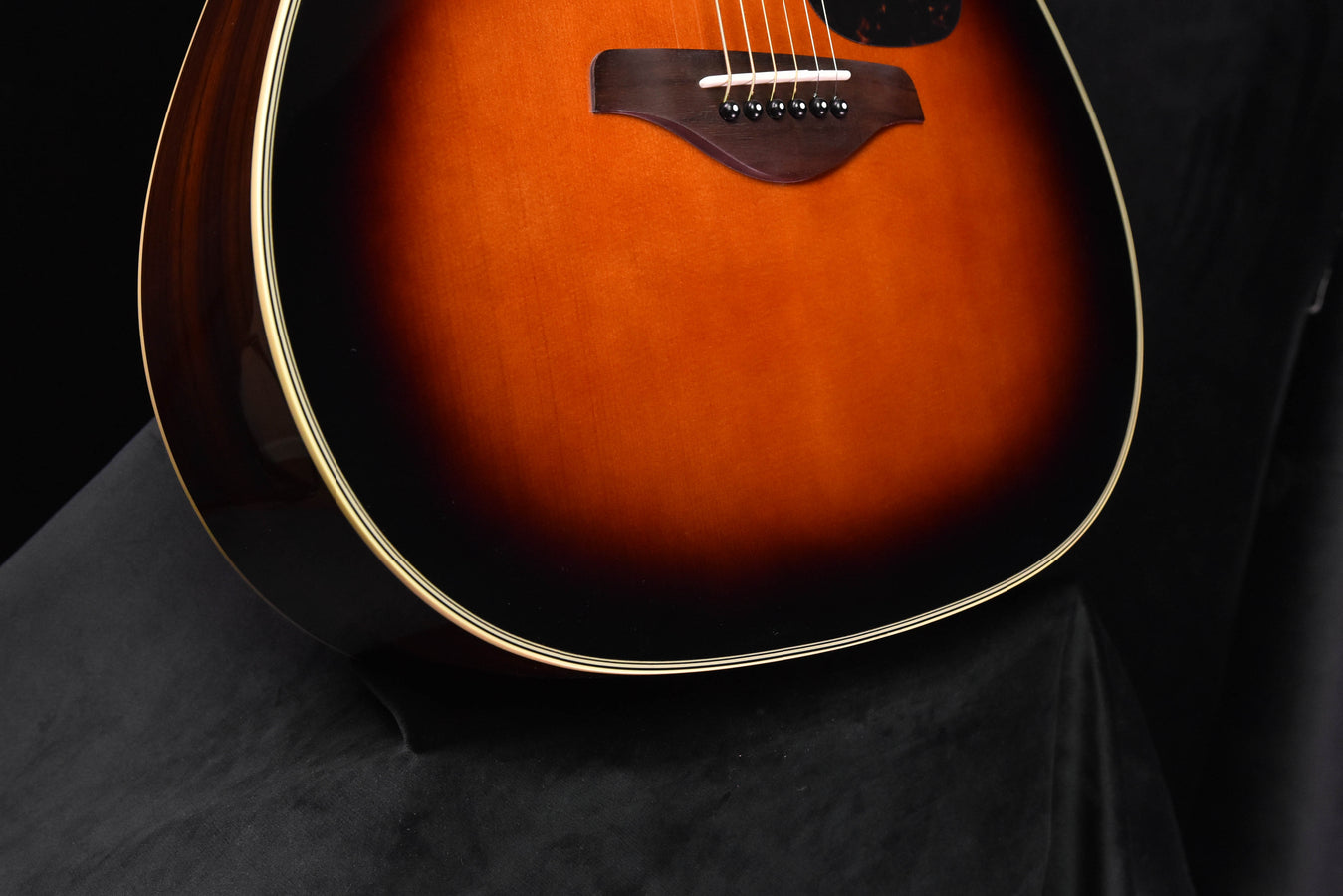 Sunburst acoustic guitar, lower bout and bridge area with white binding