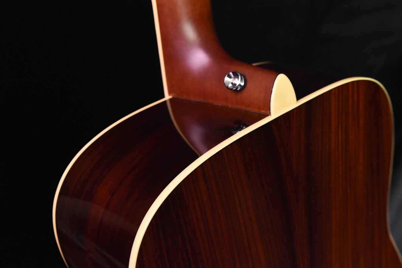 Sunburst acoustic guitar body with pickguard and chrome strap button