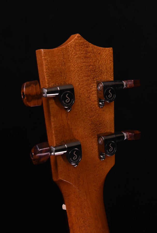 Tenor ukulele headstock back with four tuning gears on light brown wood plate