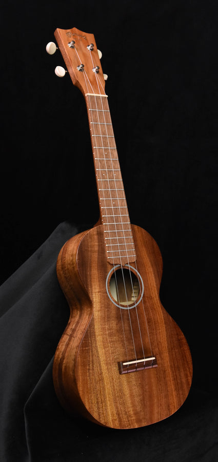 Concert ukulele All-Koa wood, front view with tuning pegs and sound hole
