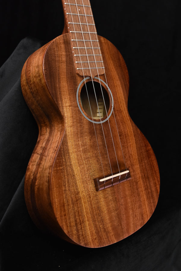 Concert ukulele All-Koa wood, close view of body, sound hole and bridge