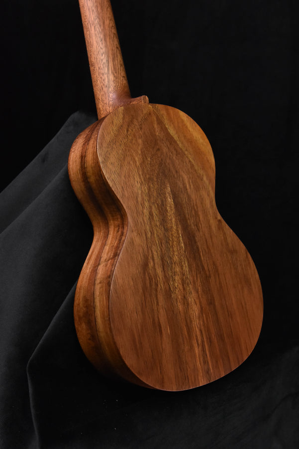 All-Koa concert ukulele body and neck, side profile with glossy wood finish