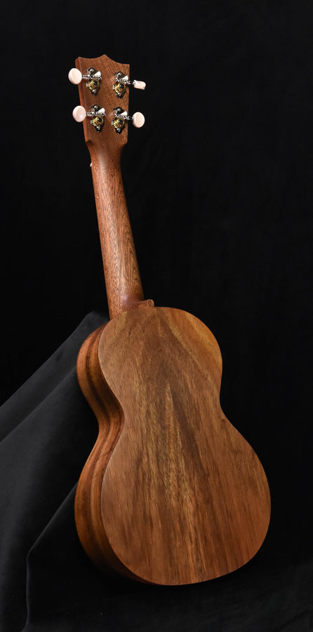 All-Koa concert ukulele, full side view showing headstock and curved body