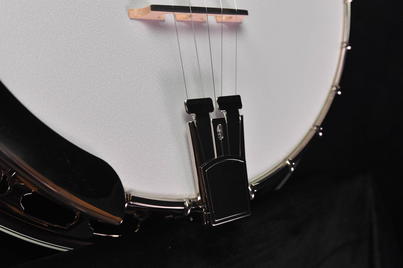 Banjo tailpiece and strings on the white drumhead, chrome rim visible