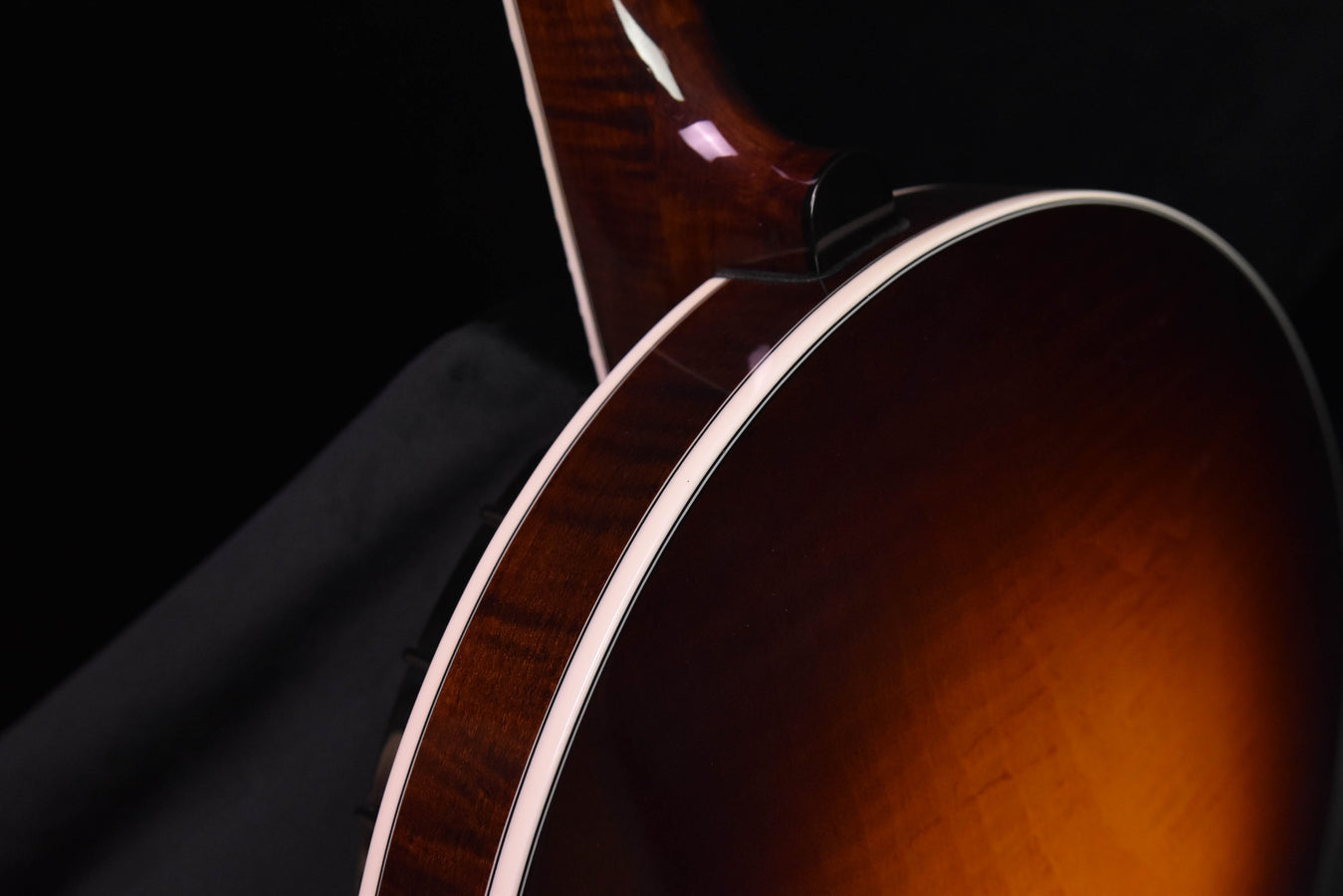 Banjo body edge and f-hole area with white binding, dark brown sunburst finish