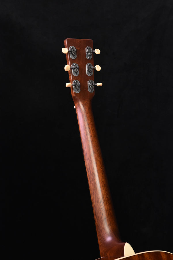 Acoustic guitar headstock with tuning pegs and logo on warm brown wood